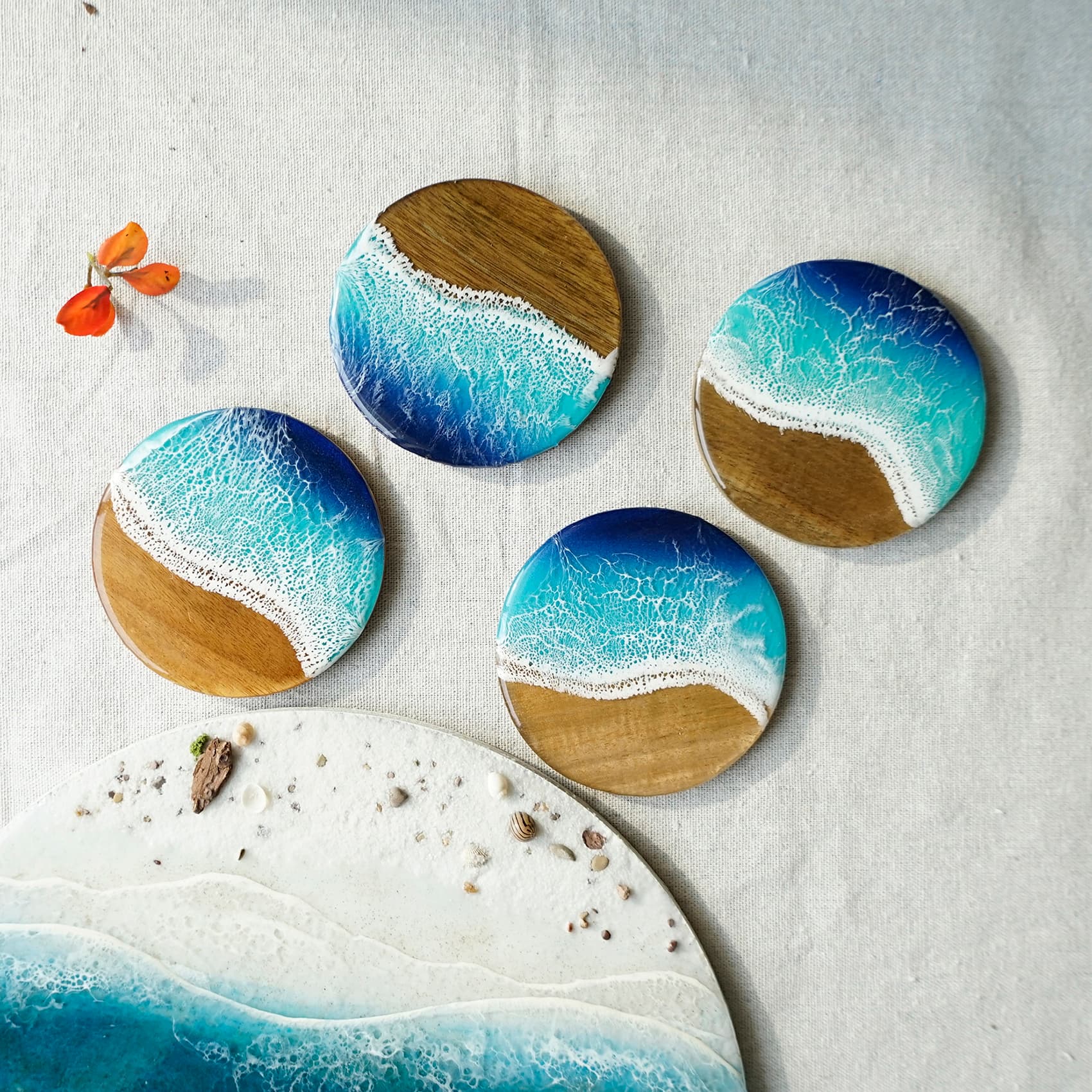 Four round coasters with ocean design on a textured surface